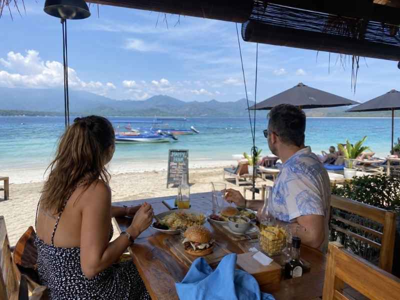 Couple enjoying lunch at a beachfront restaurant in Gili Trawangan