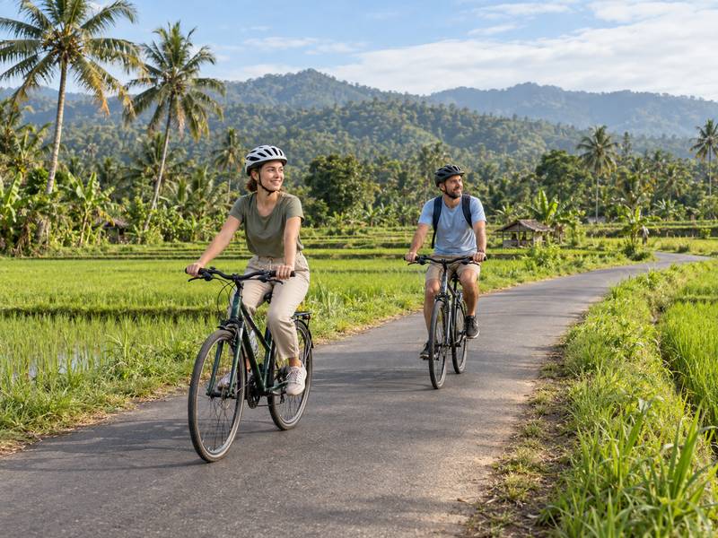 Couple cycling along a quiet countryside road in Lombok