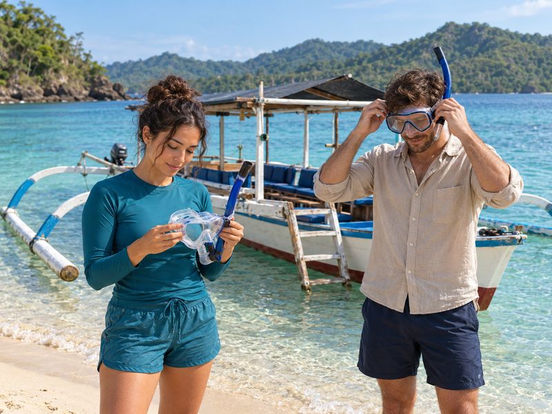 Travelers checking snorkeling masks before a Lombok boat trip