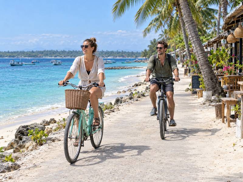 Couple cycling along a coastal path on Gili Trawangan